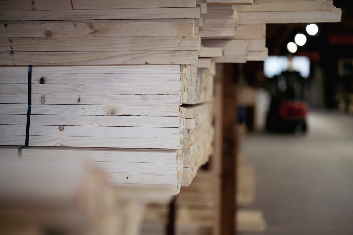 Staplade plank på hyllor i brädgården