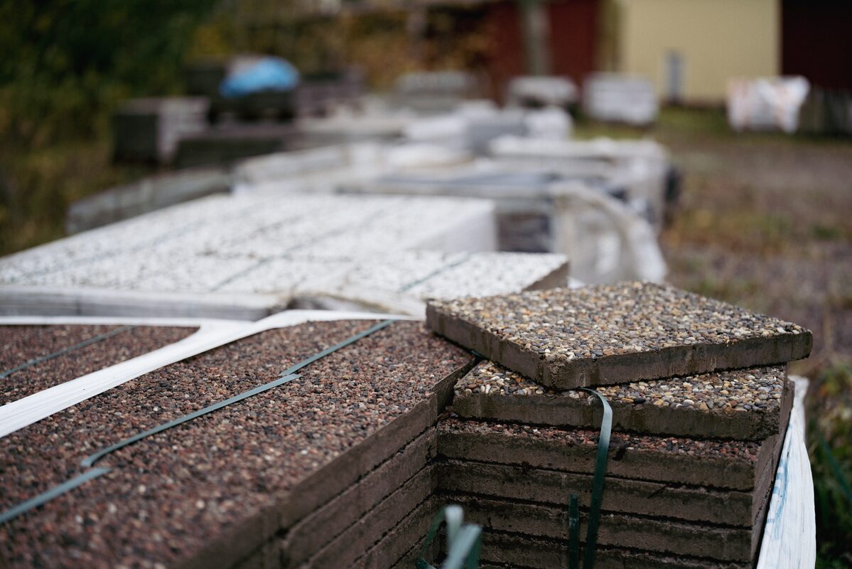 Pallar med betongplattor för uteplats på gården